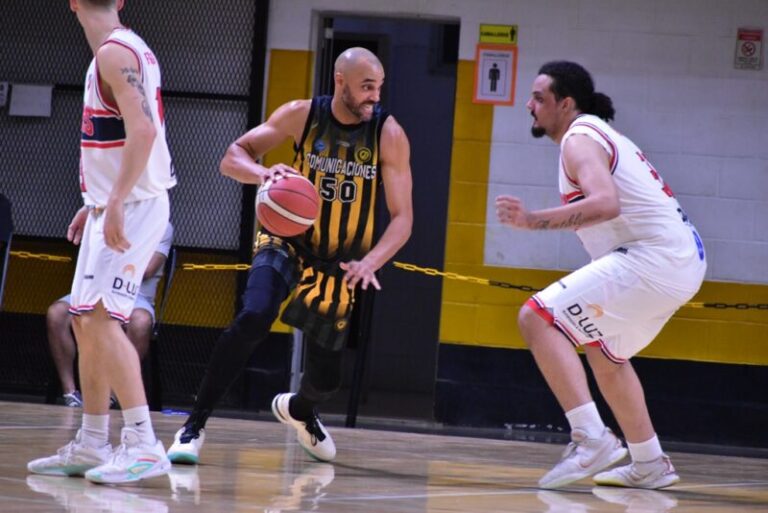 Jugadores de Comunicaciones y Bochas en acción durante el partido de básquet en Mercedes.