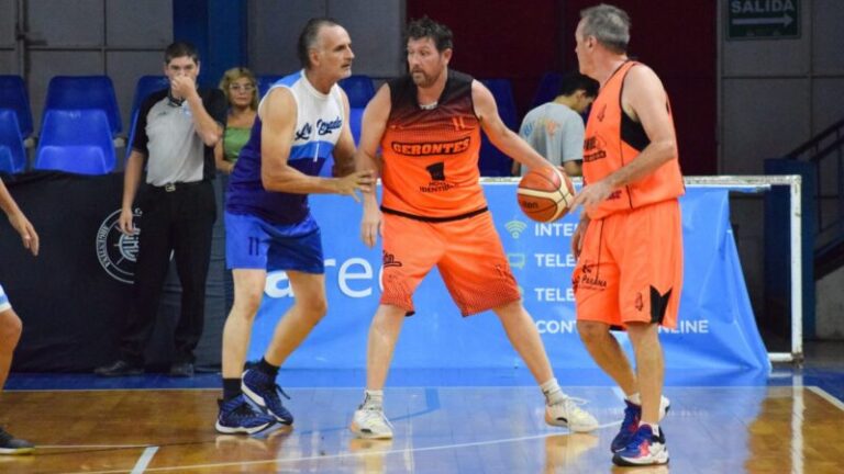 Jugadores de básquet veteranos en un partido en una cancha de parquet.