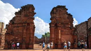 Turistas visitando un monumento histórico en una plaza de Sudamérica