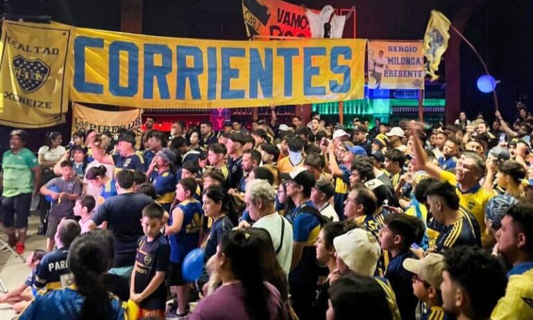 Grupo de personas viendo un partido de fútbol en una pantalla gigante en un evento solidario en Corrientes.