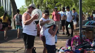 Termómetro mostrando altas temperaturas junto a un paraguas, simbolizando el cambio climático pronosticado para Corrientes.