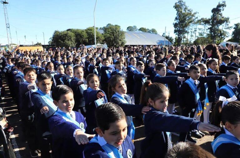 Niños realizando promesa de lealtad a la bandera en el Polideportivo Municipal de Bella Vista