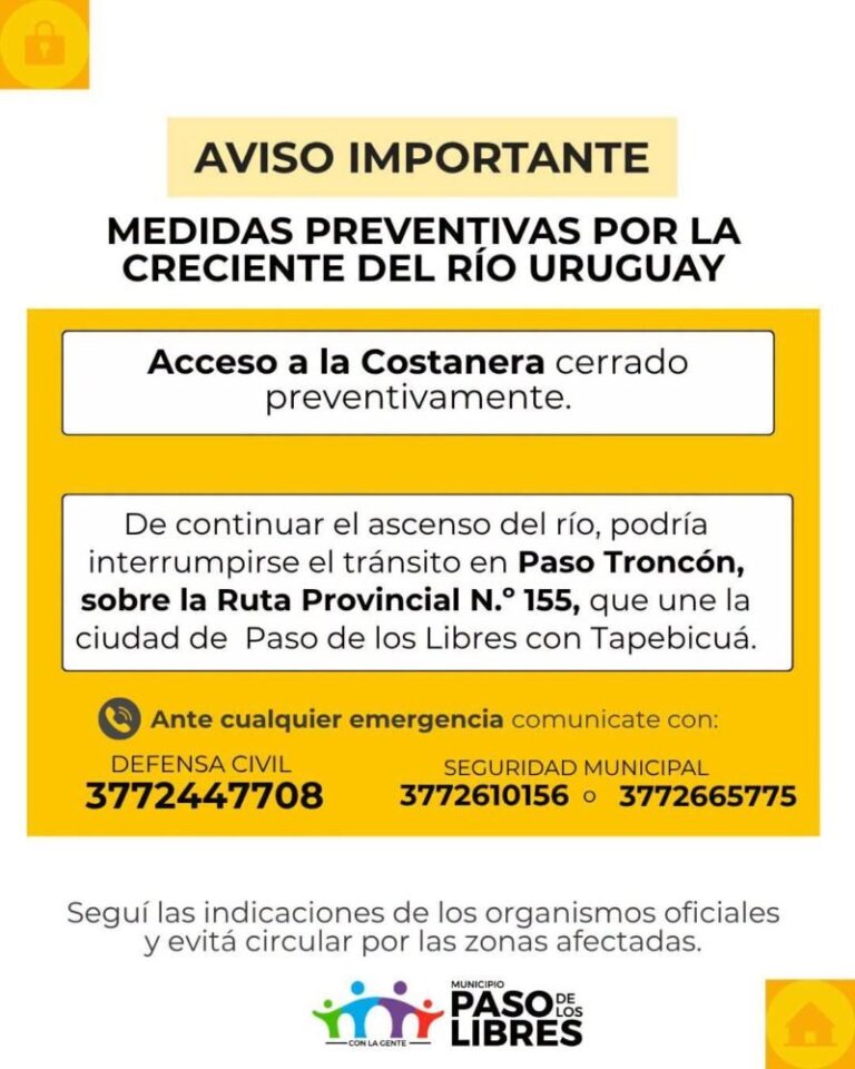 Vista del río Uruguay crecido en la costa de Paso de los Libres, con viviendas parcialmente anegadas y personal de emergencia trabajando