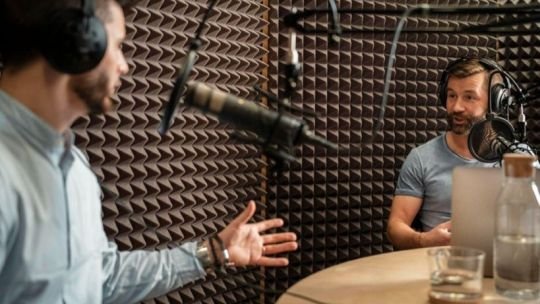 Aficionados al fútbol discutiendo un partido en un bar con radio de fondo