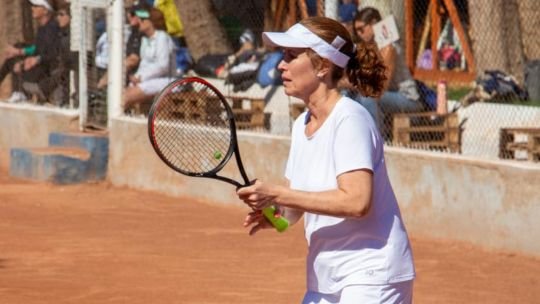 Persona jugando al tenis en una cancha al aire libre