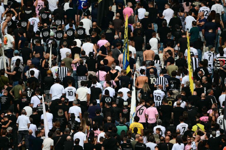 Estadio de fútbol durante un minuto de silencio con jugadores alineados