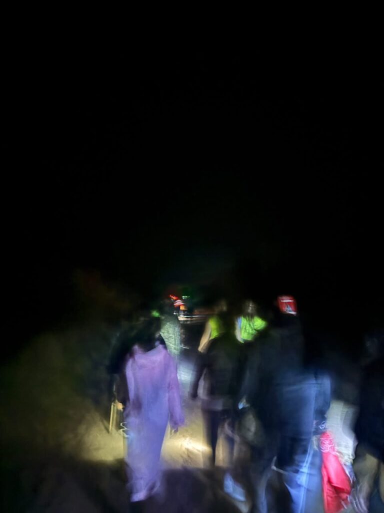 Peregrinos caminando bajo la lluvia por un camino de ripio y barro durante la peregrinación a Itatí