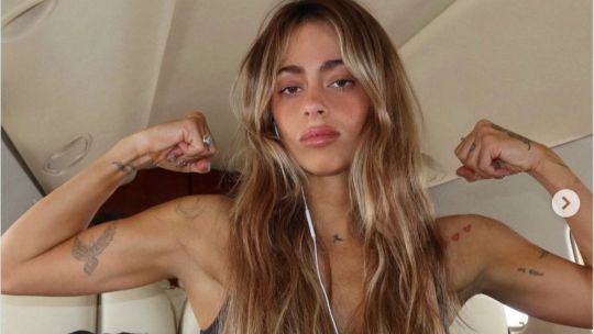 Tini Stoessel en un avión flexionando los brazos