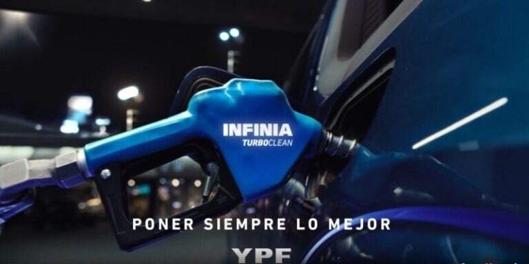 Logo de YPF junto a una estación de servicio