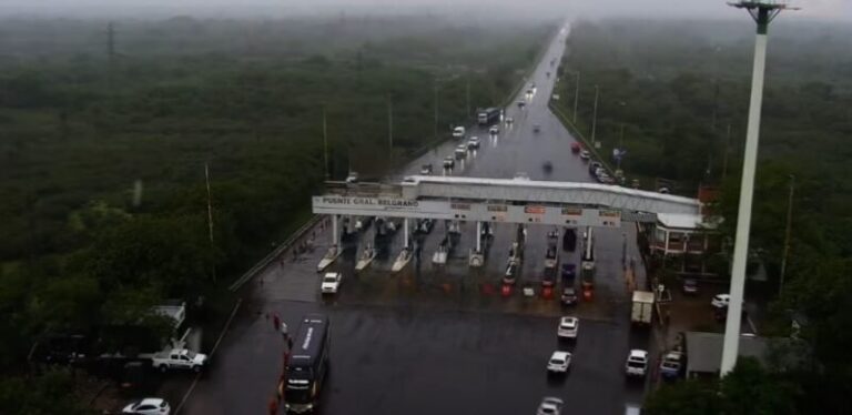 Automovilistas en fila bajo la lluvia en el peaje del puente General Belgrano entre Corrientes y Chaco